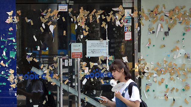 지난 4월 30일 폐업한 서울시내 프랜차이즈 상점 외벽이 홍보전단을 붙였던 테이프로 어지럽다.