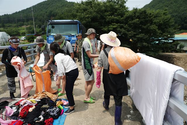 세탁물을 짊어지고 가는 힘 센 김여사, 주변의 자원봉사자와 구별이 안 되는 친근한 모습이다.청와대 제공