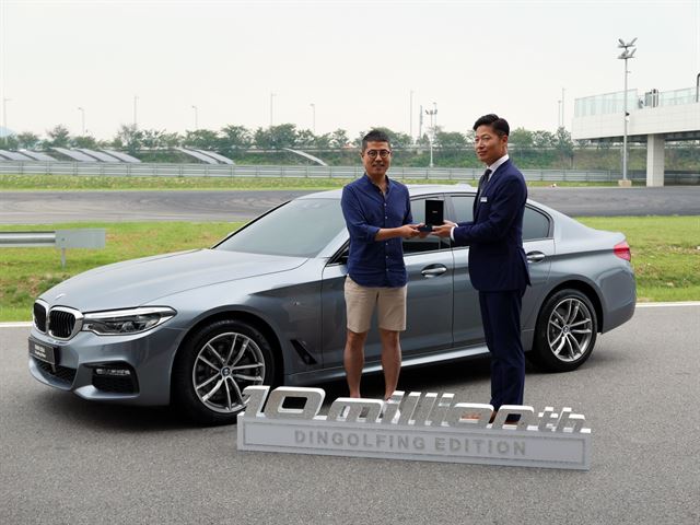 BMW 520d 딩골핑 에디션 낙찰자가 키를 전달받고 있다.