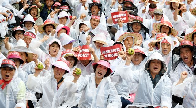 24일 오후 서울 청와대 앞 효자로에서 재해대책법 개정을 위한 우박피해농가 결의대회에 참석한 농민들이 구호를 외치고 있다. 홍인기 기자