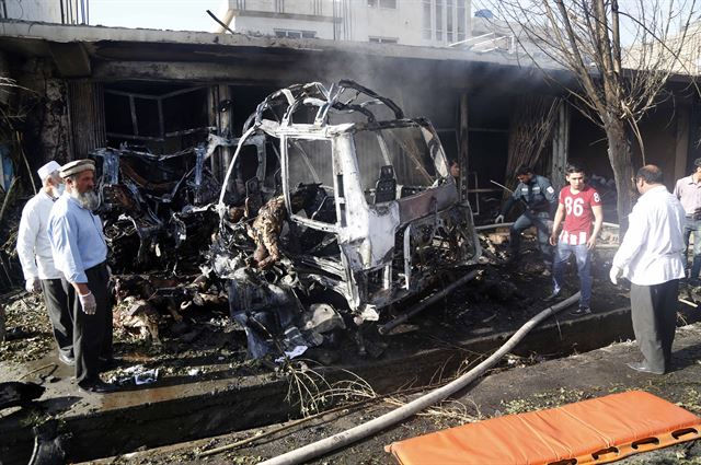 아프간 보안 당국 직원들이 24일 수도 카불 서부 구역에서 발생한 차량 폭탄테러 현장을 조사하고 있다. EPA 연합뉴스