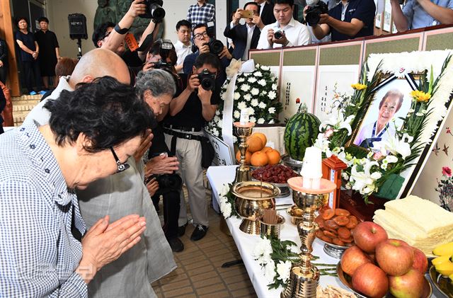 25일 오전 경기도 광주시 퇴촌면 나눔의집에서 열린 일본군 위안부 피해자 고 김군자 할머니 노제에서 이용수 할머니(왼쪽)와 박옥선 할머니가 나눔의집 원장 원행스님과 헌화를 한후 합장 하고 있다. 신상순 선임기자ssshin@hankookilbo