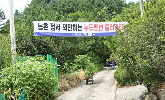 27일 충북 제천시 봉양읍 학산리 마을 입구에 누드펜션을 반대하는 플래카드가 내걸려 있다. 뉴시스