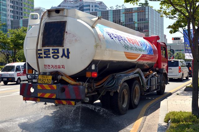 광주시가 27일 오후 서구 상무지구의 한 도로에서 여름철 폭염 대책의 하나로 살수차량을 동원해 물 뿌리기 작업을 하고 있다.