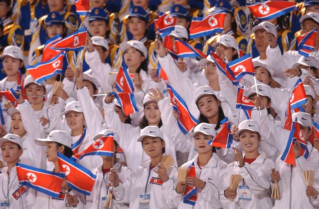 2002년 9월 부산아시안게임에 파견된 북한 여성 응원단이 축구 경기장 관중석에서 인공기를 흔들며 자기 선수단의 선전을 독려하고 있다. 한국일보 자료사진