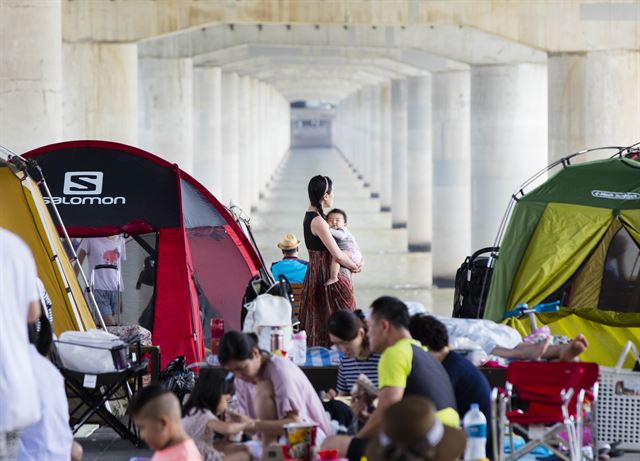 서울을 비롯한 수도권과 충청지역 등에 폭염주의보가 내려진 1일 오후 서울 마포대교 남단 밑 한강공원에서 시민들이 더위를 피해 휴식을 취하고 있다. 2017.8.1 서울=연합뉴스