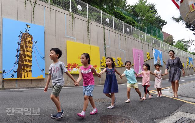 [저작권 한국일보] 2일 오전 어린이들이 서울 서초구 방배중학교 외벽에 세계 여행을 주제로 조성된 입체 테마벽화앞을 지나고 있다.