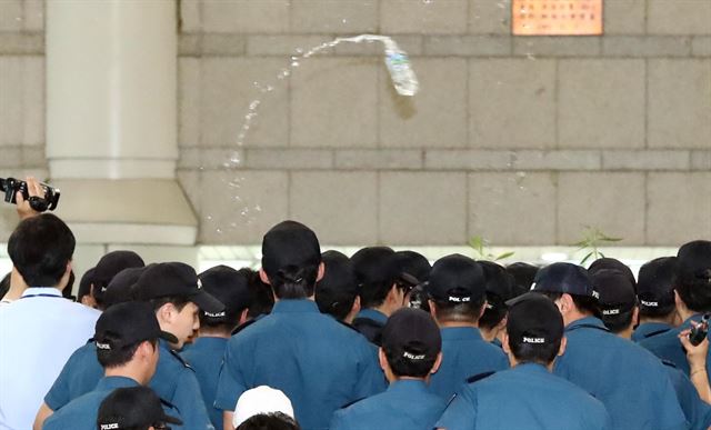 박영수 특별검사가 7일 오후 서초구 서울중앙지방법원에서 열린 이재용 삼성전자 부회장의 결심 공판에 출석하기 위해 법원으로 들어서자 박근혜 전 대통령 지지자들이 박 특검에게 생수병을 던지고 있다. 연합뉴스