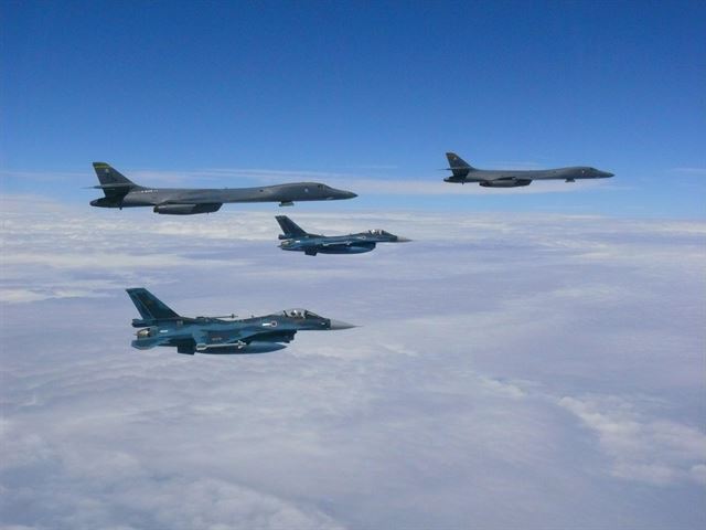 미국의 전략폭격기 B-1B 랜서 2대(상층부 왼쪽과 오른쪽)가 7일(현지시간) 괌의 앤더슨 공군기지에서 발진해 한반도 상공에서 훈련을 마친 뒤 돌아가는 길에 일본 전투기와 임무를 수행하고 있다. AFP 연합뉴스