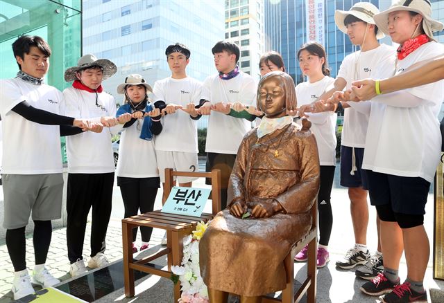 흥사단 소속 청년·학생들이 지난 7일 부산 일본영사관 앞 소녀상에서 새끼손가락을 걸고 반드시 한일 위안부 재협상을 끌어내도록 노력하겠다는 의미의 약속 퍼포먼스를 하고 있다. 부산=연합뉴스