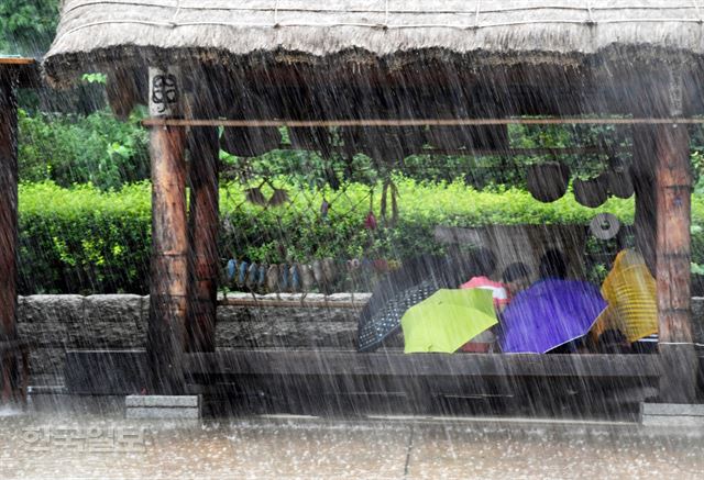 [저작권 한국일보]서울, 인천, 경기북부, 강원북부 등에 호우주의보가 발령된 15일 오전 서울 중구 한옥마을을 방문한 관람객들이 정자에 않아 장대비를 피하고 있다 .배우한 기자bwh3140@hankooklbo.co