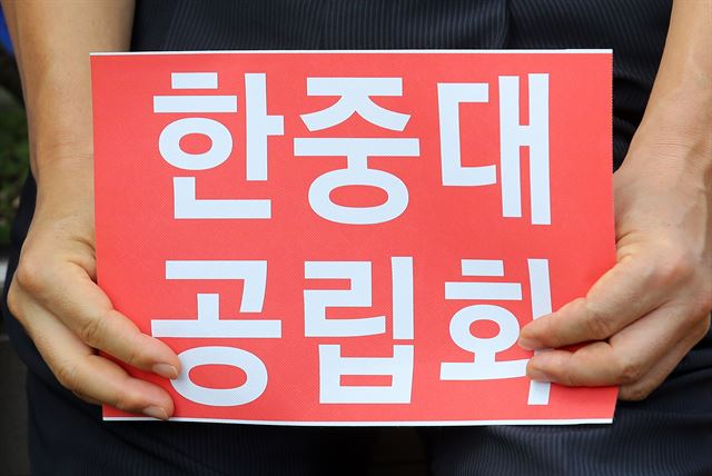 8일 오전 강원도청 앞에서 열린 ‘한중대 공립화 촉구 범시민 결의대회’에서 범시민대책위원회 회원들이 손팻말을 들고 있다. 한중대는 2차례에 걸친 감사와 대학구조개혁 평가 결과 E등급으로 평가되고 전 총장의 횡령과 330억원의 임금 체불, 학생 모집 부족 등 부실운영으로 정상 운영되지 못해 폐쇄 위기를 맞고 있다. 연합뉴스