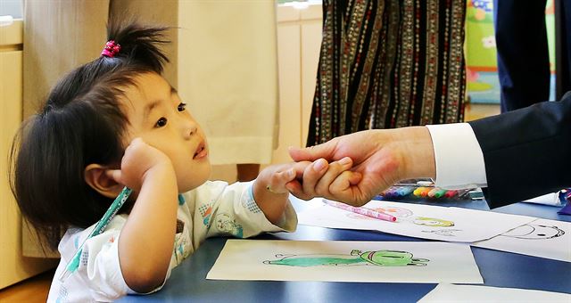 9일 건강보험 보장성 강화 정책을 발표하기 위해 서울 서초구 성모병원을 방문한 문 대통령이 입원 중인 아이의 손을 살포시 잡고 있다.