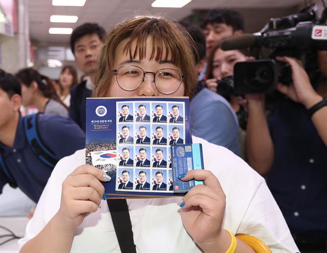 17일 오전 서울 광화문 우체국에서 한 시민이 문재인 대통령의 기념우표를 사고서 활짝 웃고 있다. 우정사업본부는 이날부터 문 대통령의 어린시절 모습, 노무현 전 대통령과 나란히 서 있는 모습, 대통령 취임식 장면 등이 담긴 기념우표를 판매한다. 가격은 우표 330 원, 시트 420 원, 기념우표첩 2만3천 원이다. 전국 총괄우체국과 인터넷우체국에서 구매가능하다. 2017.8.17 서울=연합뉴스