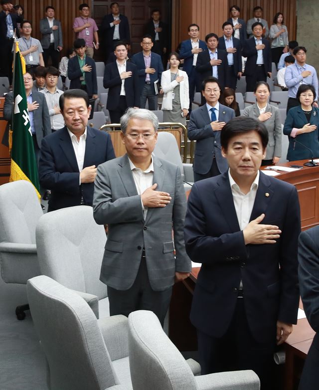 박주선(왼쪽) 국민의당 비상대책위원장과 김동철(가운데) 원내대표가 21일 국회 본청에서 열린 의원총회에 참석해 국기에 대한 경례를 하고 있다. 연합뉴스