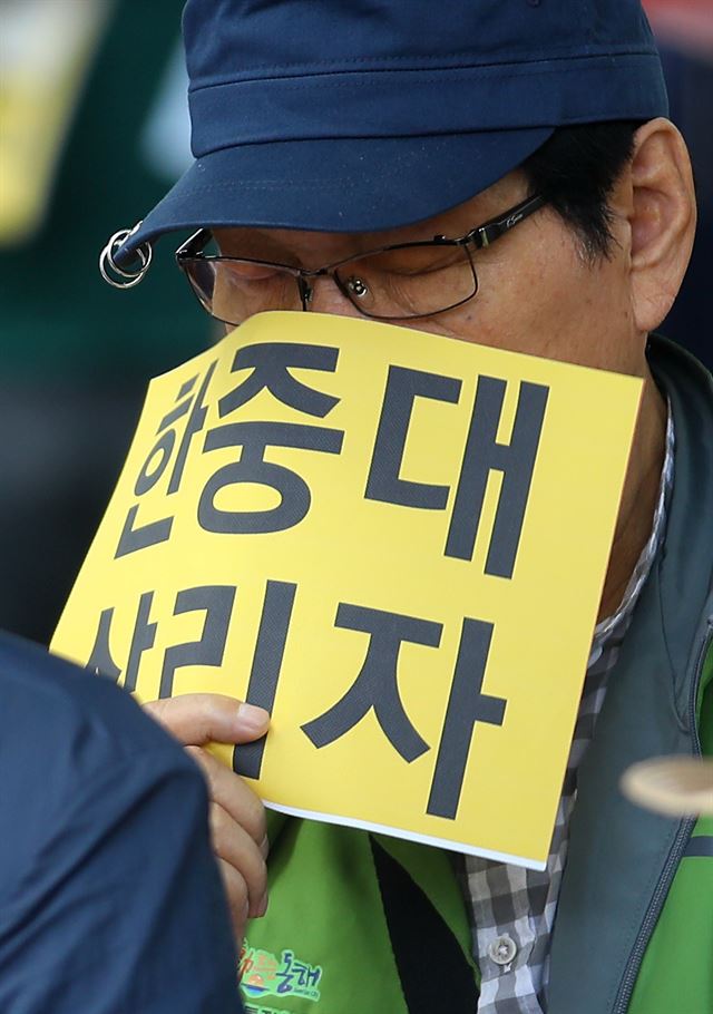 교육부가 한중대와 대구외대의 폐쇄 명령에 앞서 25일부터 행정예고에 들어간다. 지난 8일 강원 춘천 강원도청 앞에서 열린 '한중대 공립화 촉구 범시민 결의대회'에서 한중대 범시민대책위원회 회원이 손팻말을 들고 있다. 연합뉴스