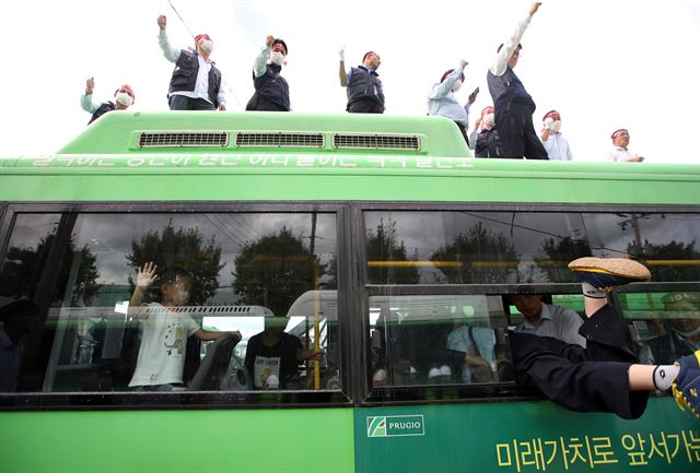 23일 서울 송파구 거여동 송파상운 차고지에서 송파상운 직원들과 철거업체 직원들이 대치, 이 모습을 버스 안의 한 어린이가 천진난만한 얼굴로 지켜보고 있다. 송파상운 차고지는 거여 2-2 주택재개발정비사업 대상지에 있다. 재개발조합 측은 재개발 추진을 위해 송파상운에 차고지를 비워달라고 요구했지만, 업체는 대체 차고지 마련이 어렵다며 맞섰다. 2017.8.23 서울=연합뉴스