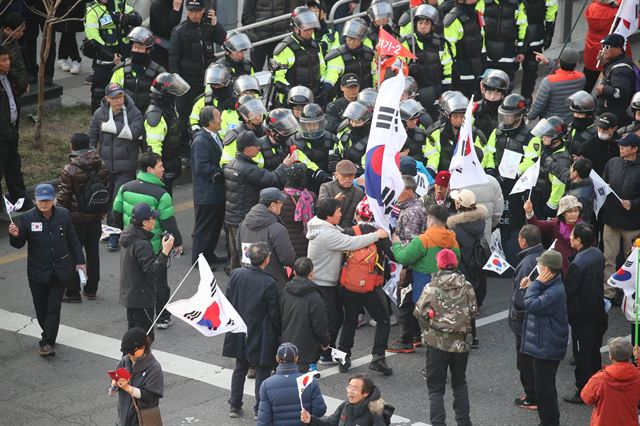 태극기집회의 한 참가자가 경찰과 충돌하자 다른 참가자들이 말리고 있다. 사진공동취재단