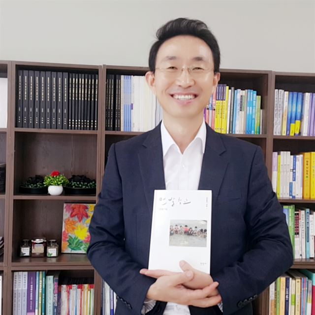 권택환 맨발학교 교장이 24일 자신이 출간한 책 '맨발학교'를 들고 환하게 웃고 있다. 맨발학교 제공