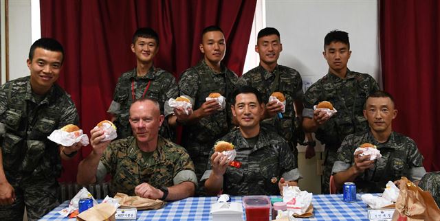 전진구 해병대 사령관(앞줄 오른쪽 두번째)과 로렌스 니콜슨 미국 3해병기동군 사령관(앞줄 왼쪽 두번째)이 25일 서해 NLL 최전방 말도에서 장병들과 햄버거를 먹고 있다. 2017.8.25 [해병대 제공=연합뉴스]