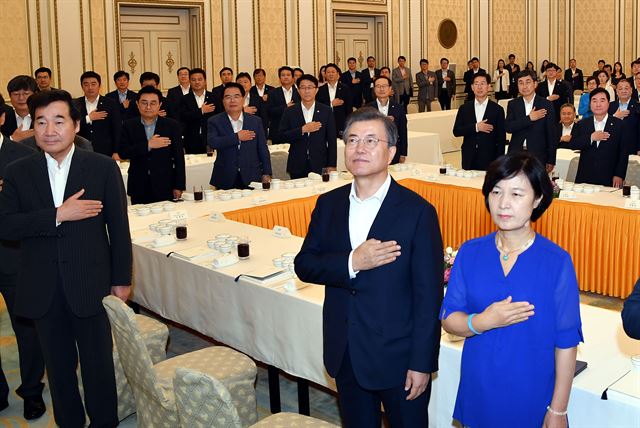 26일 청와대 영빈관에서 열린 더불어민주당 국회의원 초청 오찬 및 간담회에서 문재인 대통령과 추미애 대표등 참석자들이 국기에 대한 경례를 하고 있다.고영권기자youngkoh@hankookilbo.com