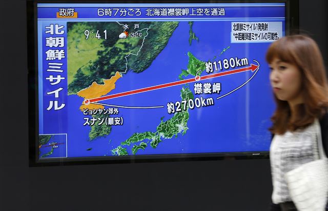 일본 도쿄에서 29일 한 여성이 북한 미사일 발사 뉴스가 나오는 TV 앞을 지나고 있다. 도쿄=AP 뉴시스