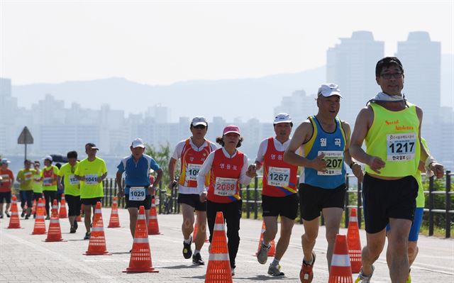 [저작권 한국일보] 서울사랑 마라톤에 출전한 선수들이 힘차게 한강변을 달리고 있다