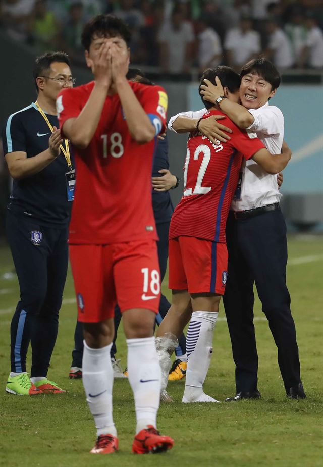 한국 김영권(왼쪽)이 6일 우즈베키스탄 타슈켄트 분요드코르 스티다움에서 우즈벡과 비겨 극적으로 월드컵 티켓을 따낸 뒤 얼굴을 감싸쥐며 감격스러워 하고 있다. 환하게 웃으며 권창훈과 포옹하고 있는 신태용 감독. 타슈켄트=연합뉴스