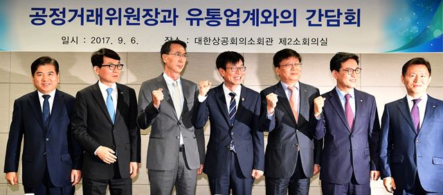 김상조 공정거래위원장(가운데)이 6일 오전 서울 중구 남대문로 대한상의에서 유통업계 대표들과 만나 기념촬영을 하다 파이팅을 외치고 있다. (왼쪽부터) 김도열 면세점협회 이사장, 박동운 백화점 협회장, 이갑수 체인스토어협회 회장, 김상조 위원장, 김형준 온라인쇼핑협 부회장, 조윤성 편의점 산업협회장. 연합뉴스