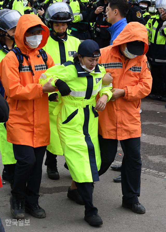 사드(THAAD·고고도미사일방어체계) 발사대 4기 추가배치가 예정된 7일 새벽 경북 성주군 초전면 소성리 마을회관 앞에서 경찰이 사드배치 반대 집회 참가자들을 강제해산시키고는 과정에 한 여경이 부상을 입고 후송되고 있다. 성주=홍인기 기자