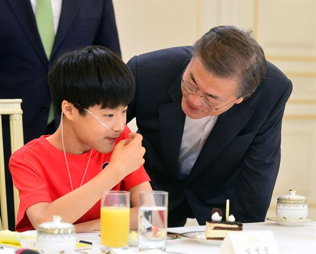 환경부와 한국환경산업기술원은 11일 3차 구제계정운용위원회를 열고 가습기 살균제 피해자로 인정받지 못한 ‘3단계’ 판정자의 지원 방안을 결정했다. 문재인 대통령이 특별법 시행 이전인 8월 8일 오후 청와대 인왕실에서 열린 가습기 살균제 피해자 간담회에 참석한 피해자 임성준 군과 얘기를 나누고 있다. 연합뉴스