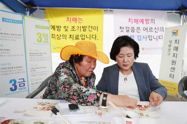 12일 오전 서울시청 광장에서 열린 서울시 주관 '치매극복의 날'기념행사에 참석한 김정숙여사가 어르신과 함께 기억주머니 만들기 체험하고 있다. 청와대제공