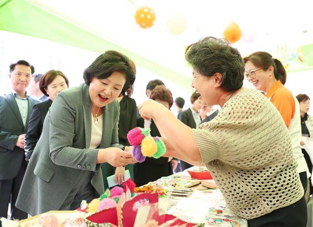 12일 오전 서울시청 광장에서 열린 서울시 주관 '치매극복의 날'기념행사에 참석한 김정숙여사가 치매 어르신 운영 바자회 부스를 방문해 물건을 구매하고 있다. 청와대제공