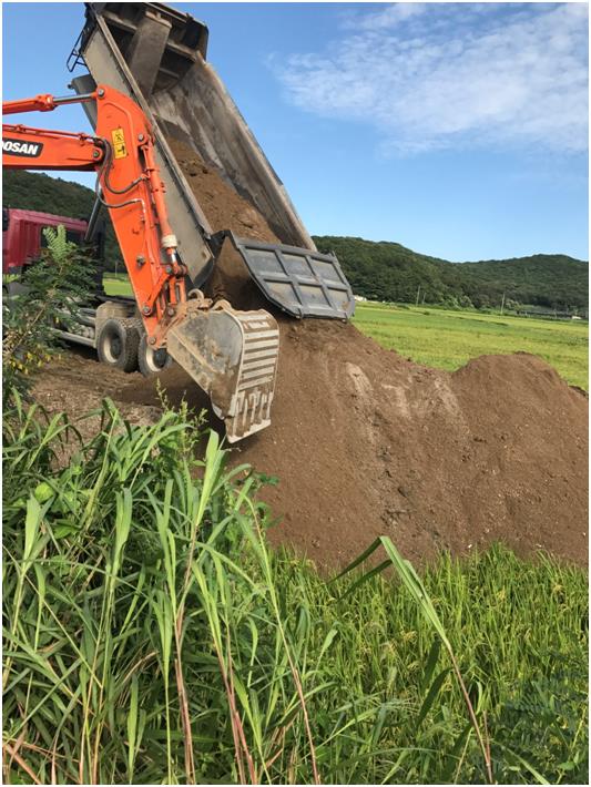 8월 26일 경기 김포시의 한 농지에 덤프트럭이 매립용 흙을 쏟아 붓고 있다. 김포시 제공