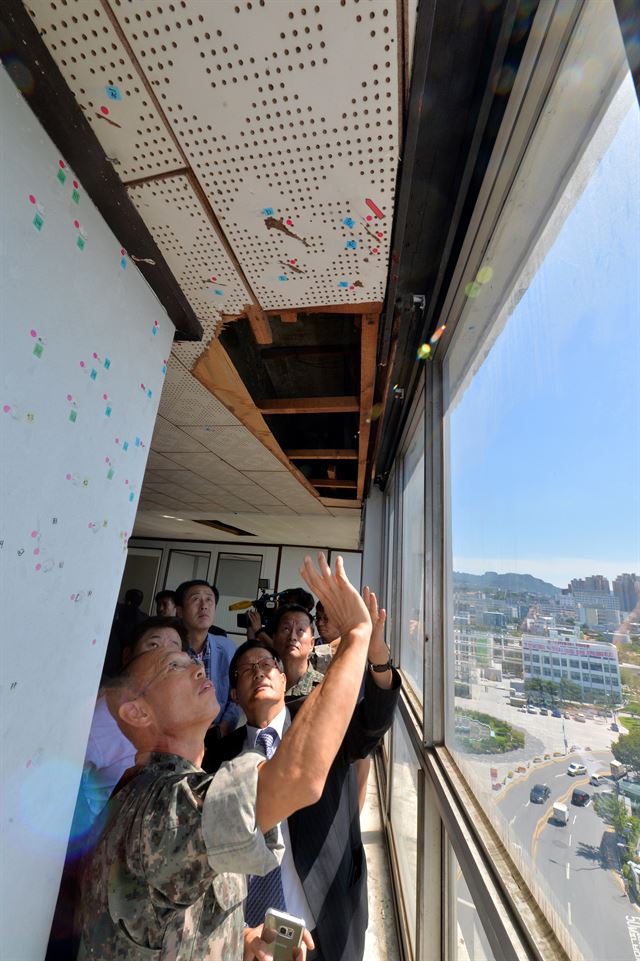 국방부 5·18특별조사위원회가 13일 오후 광주 동구 전일빌딩에서 국과수 감식결과 1980년 5·18 당시 헬기사격이 이뤄진 것으로 추정된 탄흔을 살펴보고 있다. 광주=연합뉴스