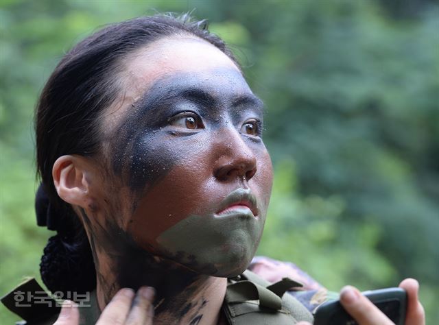 충북 괴산 육군학생군사학교 하계입영훈련에서 학군사관후보생(ROTC)들이 기본전투에 앞서 여군후보생이 위장 크림을 바르고 있다. 한국일보 자료사진