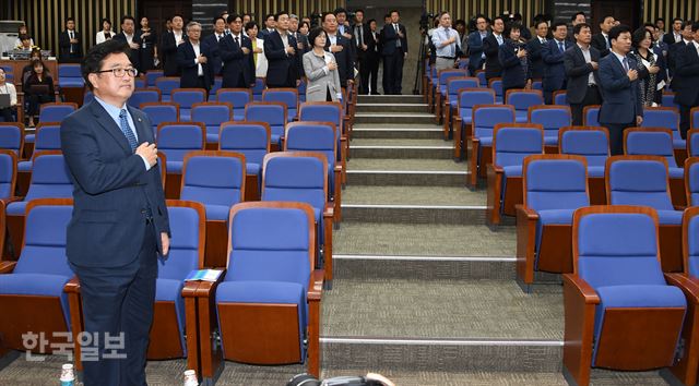 우원식 원내대표가 14일 국회에서 열린 의원총회에서 앞줄에 홀로 서 국민의례를 하고 있다. 추미애 대표도 불참한 가운데 원내부대표단 마저 멀리 서 있어 ‘고립무원?’ 인듯한 모습이다. 오대근기자 inliner@hankookilbo.com