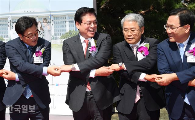 더불어민주당 우원식원내대표와 자유한국당 정우택, 국민의당 김동철, 바른정당 주호영원내대표가 14일 국회 잔디광장에서 열린 `국회 취업박람회' 행사에 참석해 개막 세레머니 도중 손을 잡고 있다. 공교롭게 야3당 원내대표가 어깨를 나란히 밀착해 우 원내대표만 사이가 벌어져 있어 보이고 있다. 오대근기자 inliner@hankookilbo.com