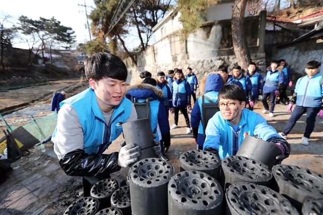 지난 1월 10일 대우건설 신입사원들이 서울시 성북구 보국문로 29길 일대 저소득층 가구에 연탄을 배달하는 봉사활동을 하고 있다. 이날 총 68명의 신입사원들은 독거노인, 기초생활수급자 등 저소득층 50가구에 총 5,000장의 연탄을 직접 배달했다. 대우건설 제공