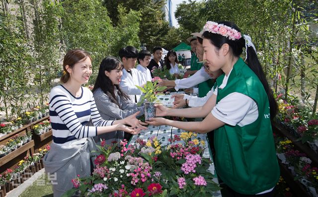 [저작권 한국일보] 스타벅스 바리스타들이 친환경 체험을 한 시민들에게 꽃 화분을 전달하고 있다.