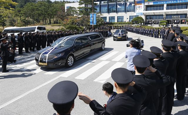 19일 오전 강원 강릉시청에서 열린 강원도 순직 소방공무원 합동 영결식이 끝난 뒤 운구차가 동료 소방관들의 경례를 받으며 국립대전현충원으로 향하고 있다. 강릉소방서 경포 119안전센터 소속 이영욱(59) 소방경과 이호현(27) 소방교는 지난 17일 강릉시 강문동 석란정에서 불을 끄다 순직했다. 연합뉴스