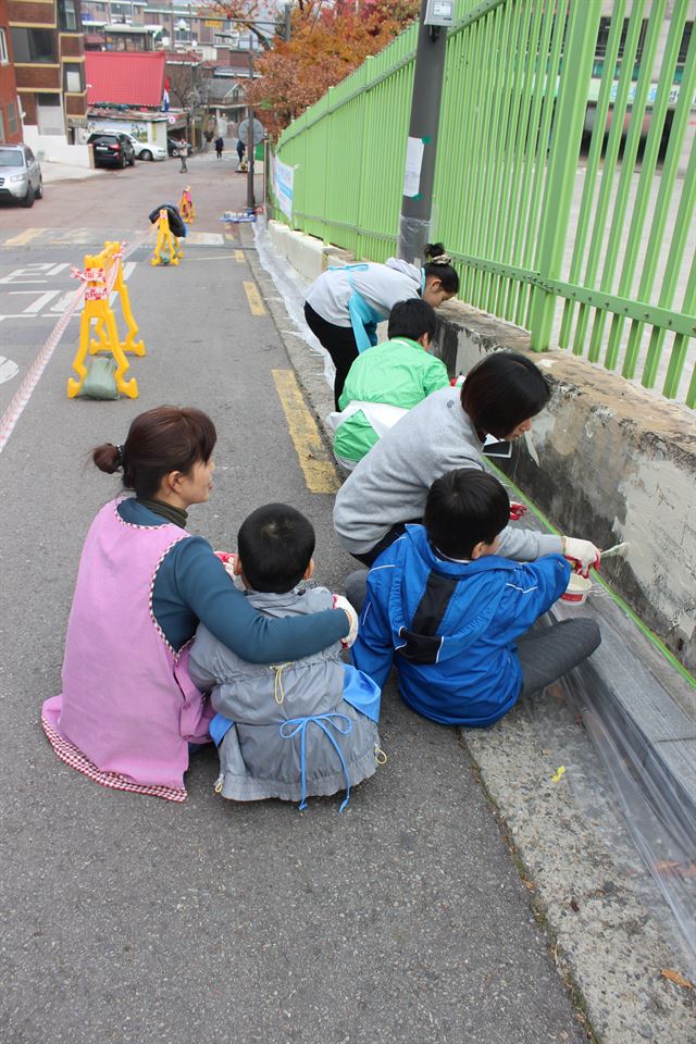 그림 1정문학교 학생, 교사들이 지난해 11월 지역 주민들과 함께 학교 담장을 색칠하고 있다. 정문학교 제공