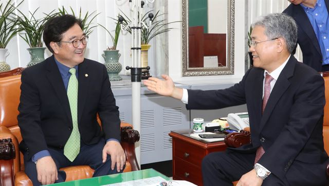 우원식(왼쪽) 더불어민주당 원내대표가 21일 국회에서 열린 본회의에서 김명수 대법원장 후보자의 임명동의안이 통과된 뒤 김동철 국민의당 원내대표와 밝은 표정으로 대화하고 있다. 연합뉴스