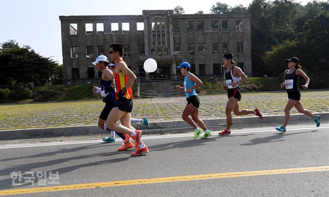 한국일보와 강원 철원군이 공동주최하고 철원군체육회가 주관한 '철원 DMZ국제평화마라톤대회'가 24일 강원도 철원군 일대에서 열렸다. 참가자들이 민통선 내 노동당사 앞을 지나고 있다. 서재훈기자