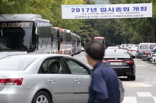 반포주공1단지 공동사업시행 건설업자 선정 등을 위한 2017년 임시총회가 개최되는 27일 서울 반포주공1단지에 관련 현수막이 걸려있다. 그 옆으로 조합원들을 태울 버스가 주차돼 있다. 서울=연합뉴스