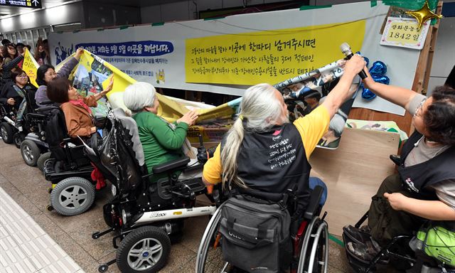 장애인단체 회원들이 5일 서울지하철5호선 광화문역 지하도에서 5년간의 농성을 마무리하고 있다. 문재인 정부가 국정과제로 장애등급제와 부양의무제의 단계적 폐지를 약속한 데 따른 것이다. 배우한 기자