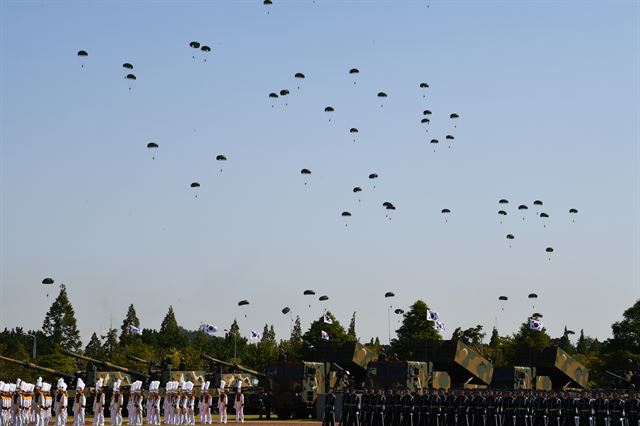 28일 경기도 평택 해군 제2함대 사령부에서 열린 국군의 날 행사에 국군의 최신 무기들이 도열해 있는 가운데 특전사 장병들이 강하시범을 보이고 있다. 국군의날 행사가 해군기지에서 열리는 것은 창군 이후 처음이다. 이번 행사에선 우리 군의 북한 타격용 무기들을 대거 공개했다. 평택=청와대사진기자단