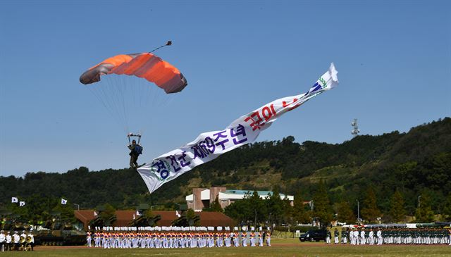 28일 경기도 평택 해군 제2함대 사령부에서 열린 국군의 날 행사에 국군의 최신 무기들이 도열해 있는 가운데 특전사 장병들이 강하시범을 보이고 있다. 국군의날 행사가 해군기지에서 열리는 것은 창군 이후 처음이다. 이번 행사에선 우리 군의 북한 타격용 무기들을 대거 공개했다. 평택=청와대사진기자단