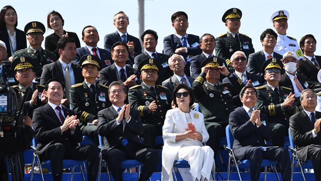 28일 경기도 평택 해군 제2함대 사령부에서 열린 국군의 날 행사에 국군의 최신 무기들이 도열해 있는 가운데 문재인대통령이 공군 특수비행팀 블랙이글스의 축하비행을 지켜보며 박수를 치고 있다. 국군의날 행사가 해군기지에서 열리는 것은 창군 이후 처음이다. 이번 행사에선 우리 군의 북한 타격용 무기들을 대거 공개했다. 평택=청와대사진기자단