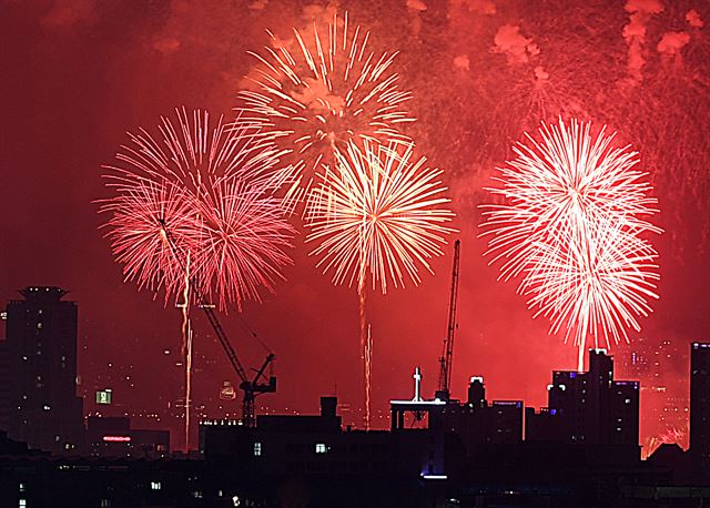 30일 오후 서울 용산구 건설 현장 타워크레인 뒤로 2017 서울불꽃축제 폭죽이 밤하늘을 수놓고 있다. 김주영기자 will@hankookilbo.com